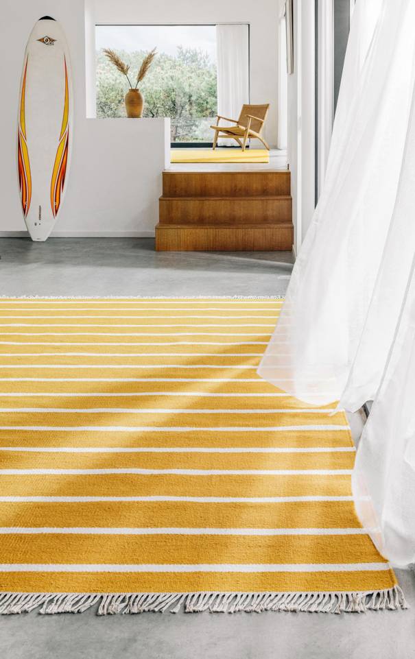 Brown / yellow  röllakan / dhurrie -  Carpet in a living room.