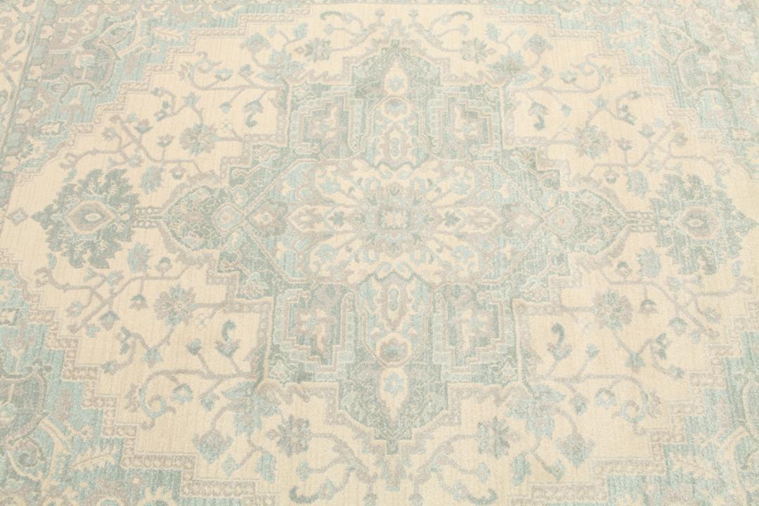 Cremefarvet og lyseblåt tæppe med et traditionelt mønstret design