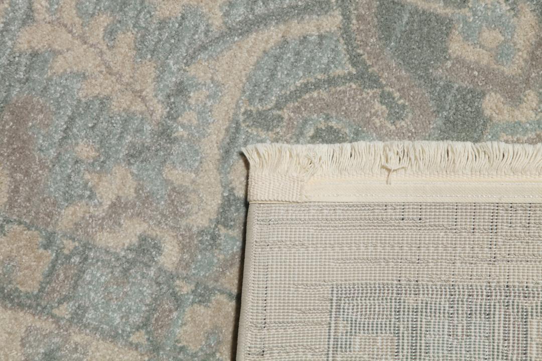 Cremefarvet og lyseblåt tæppe med et traditionelt mønstret design