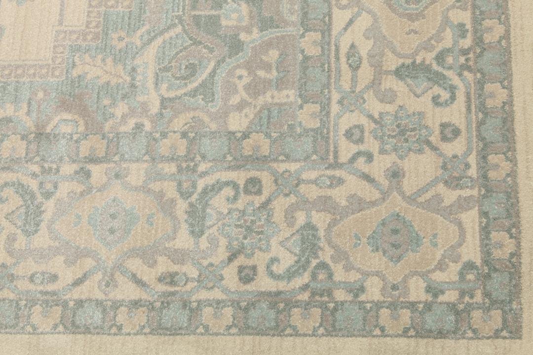 Cremefarvet og lyseblåt tæppe med et traditionelt mønstret design