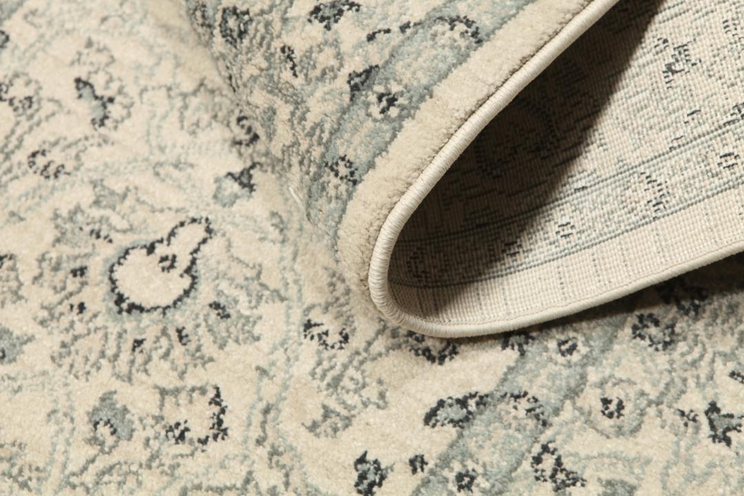 Beige og grønt løbertæppe med detaljeret mønster