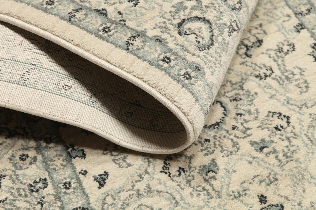 Beige og grønt løbertæppe med detaljeret mønster