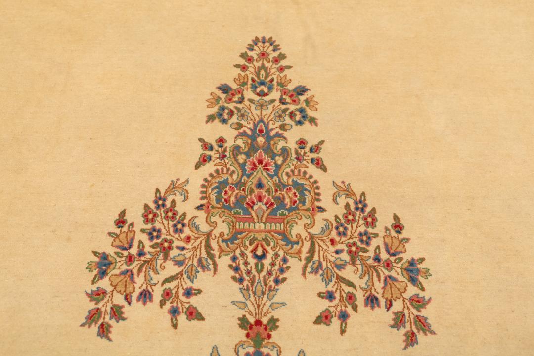 Large Kerman rug from the Middle East featuring a central floral medallion in beige, blue, and pink tones.