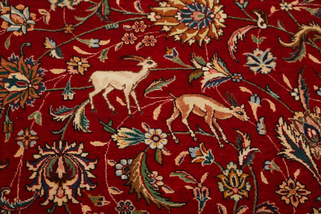 Groot handgeknoopt Tabriz-tapijt met ingewikkelde bloemen- en dierenpatronen op een rode achtergrond.