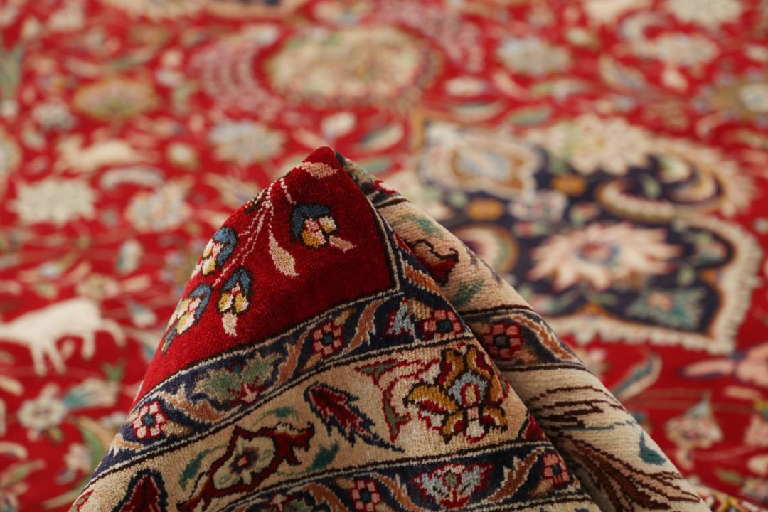 Groot handgeknoopt Tabriz-tapijt met ingewikkelde bloemen- en dierenpatronen op een rode achtergrond.