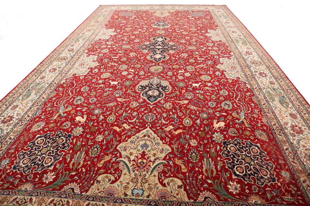 Groot handgeknoopt Tabriz-tapijt met ingewikkelde bloemen- en dierenpatronen op een rode achtergrond.