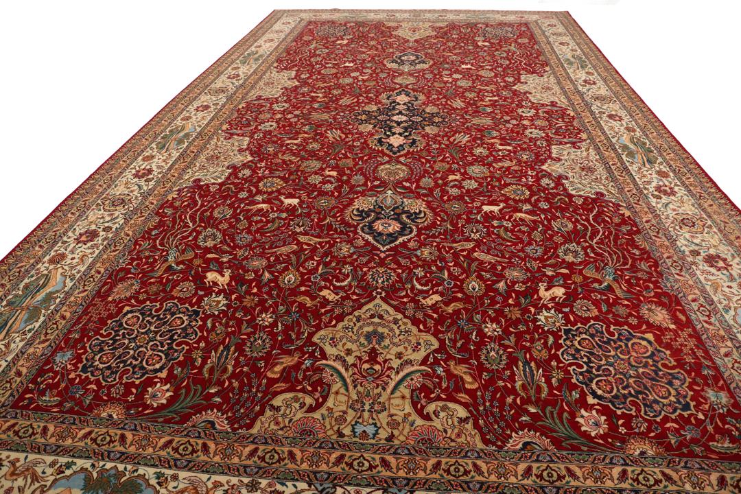 Groot handgeknoopt Tabriz-tapijt met ingewikkelde bloemen- en dierenpatronen op een rode achtergrond.