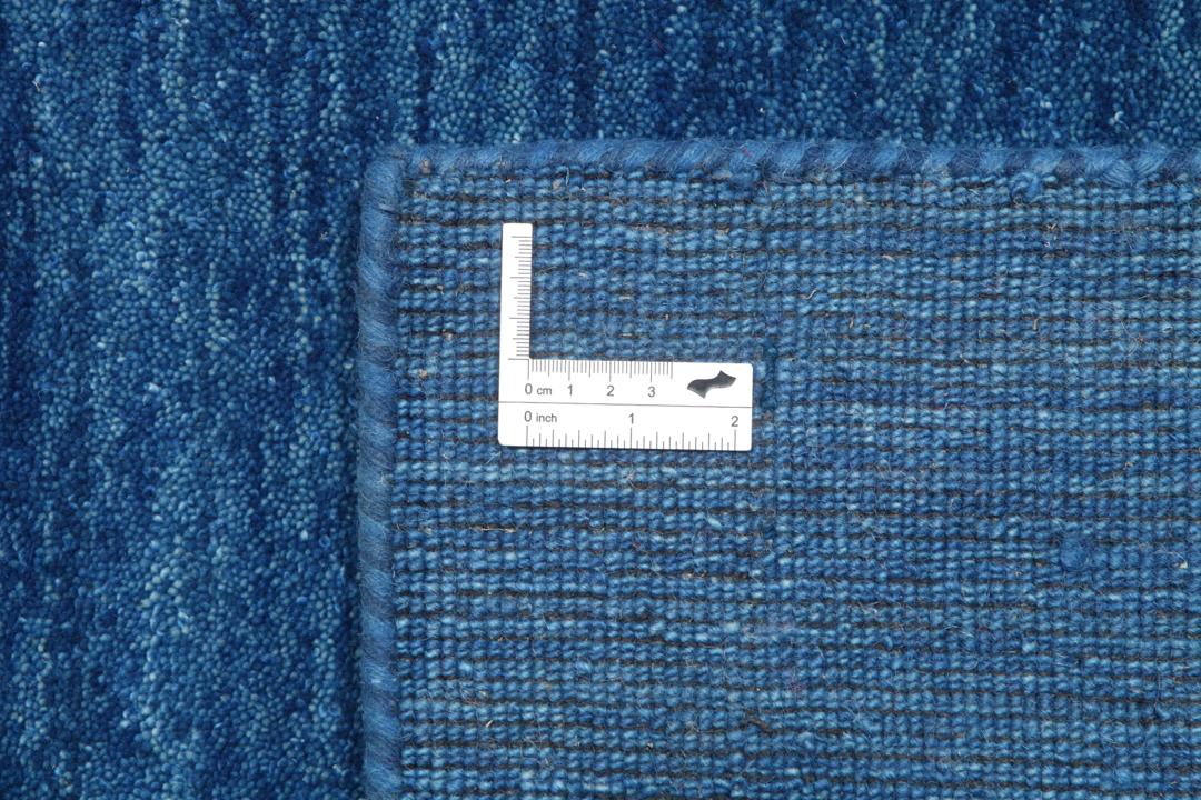 Blauw tapijt met wollen pool en motieven