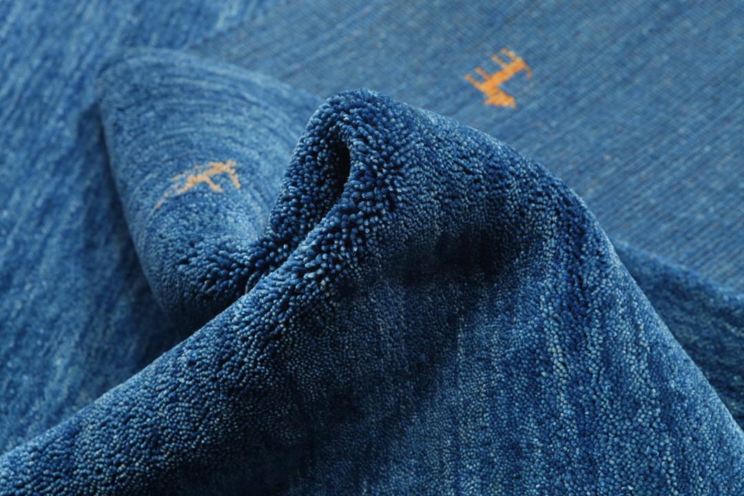 Blauw tapijt met wollen pool en motieven