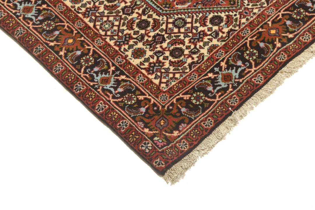 Een met de hand geknoopte loper uit het Midden-Oosten in de stijl van Bidjar met een rood en beige geometrisch patroon.