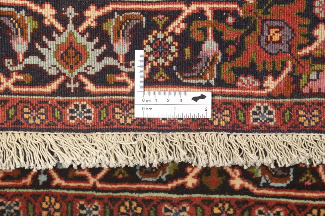 Een met de hand geknoopte loper uit het Midden-Oosten in de stijl van Bidjar met een rood en beige geometrisch patroon.