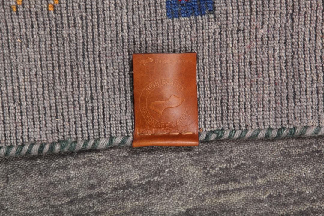 Een lange, grijze loper met kleine, kleurrijke geometrische motieven en een zachte wollen pool.