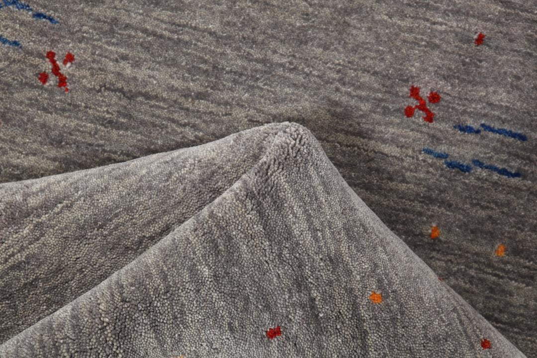 Een lange, grijze loper met kleine, kleurrijke geometrische motieven en een zachte wollen pool.