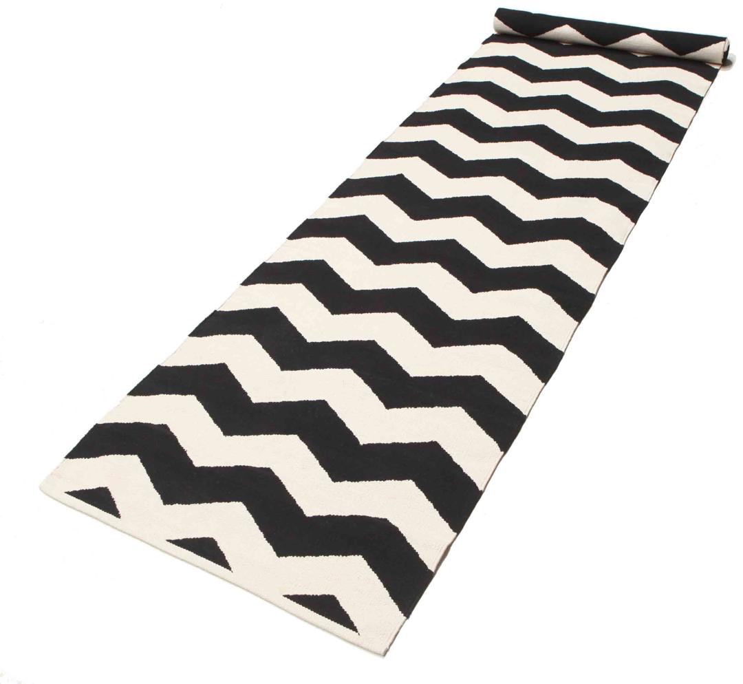 En sort og hvid løber med et gentagende zigzag-mønster.