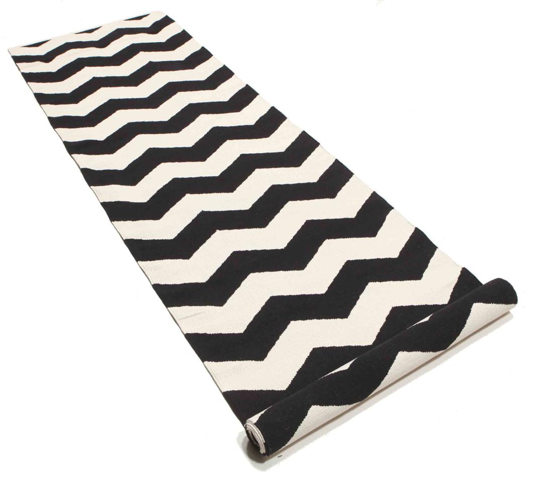 En sort og hvid løber med et gentagende zigzag-mønster.