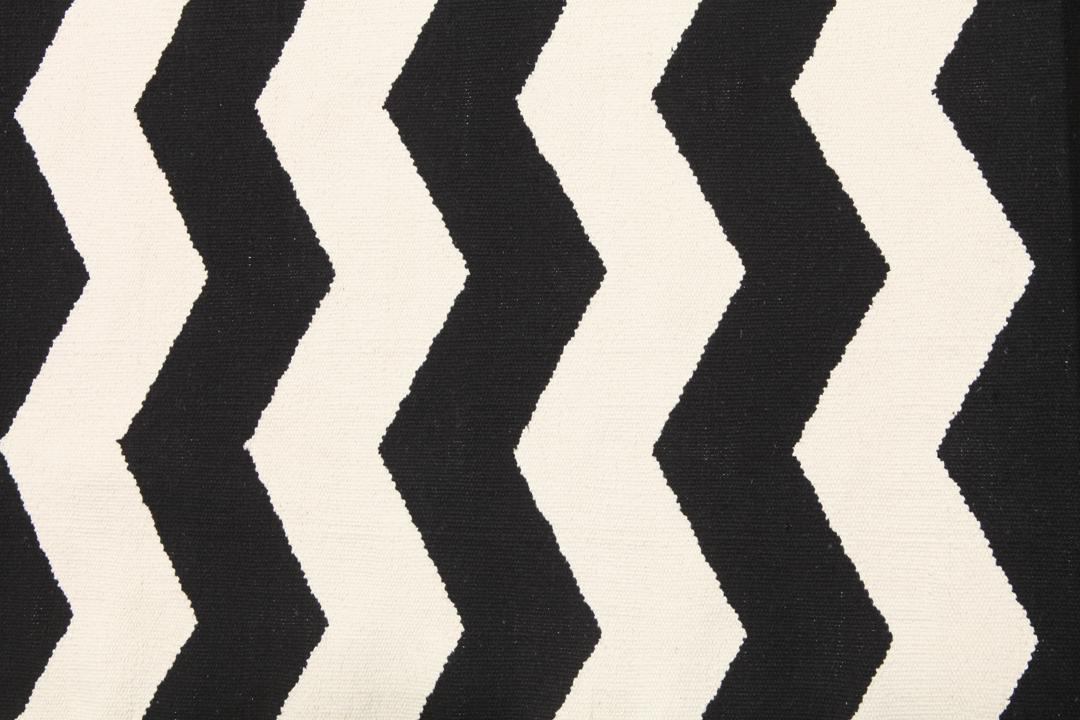 En sort og hvid løber med et gentagende zigzag-mønster.
