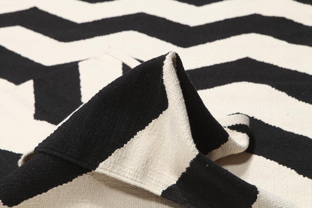 En sort og hvid løber med et gentagende zigzag-mønster.