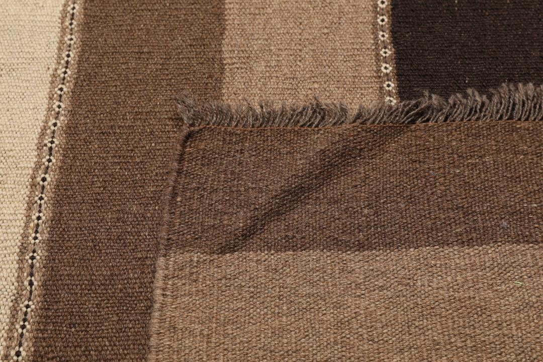 Håndvævet Kelim-tæppe fra Mellemøsten med et brunt og beige stribet mønster.