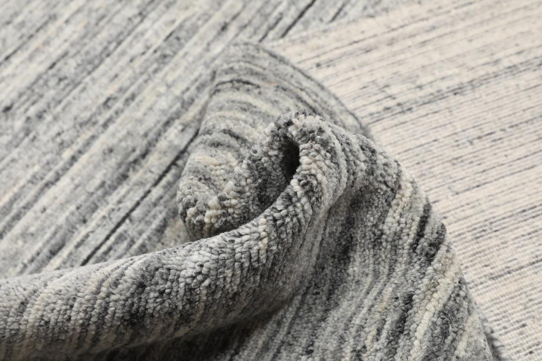 Um tapete de lã cinzento texturado com linhas horizontais subtis