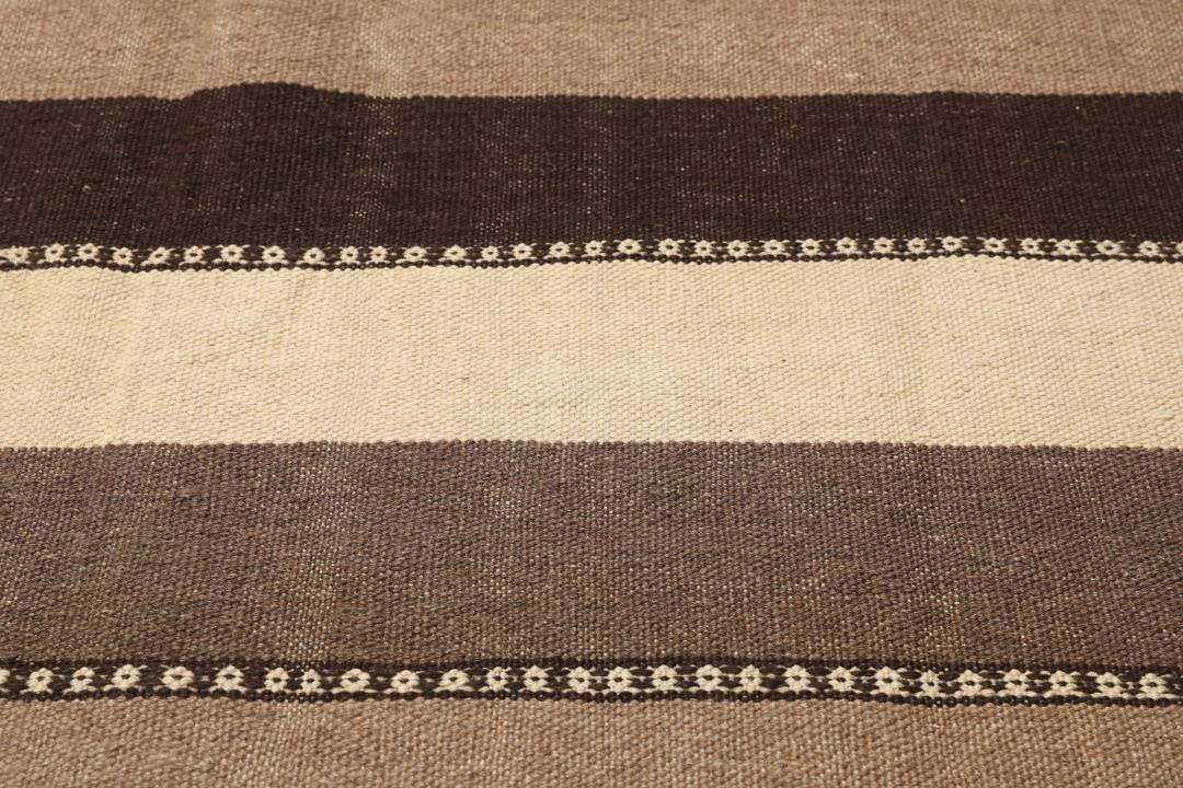 Handgeweven Kilim-tapijt uit het Midden-Oosten met een gestreept patroon in beige en bruine tinten.