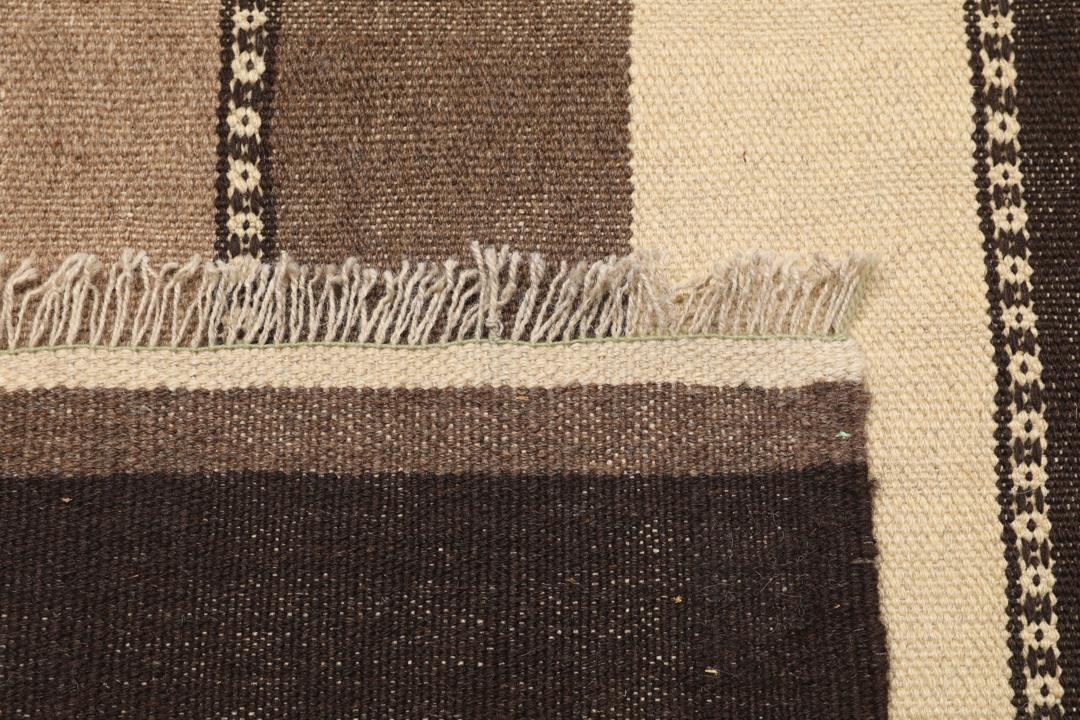 Handgeweven Kilim-tapijt uit het Midden-Oosten met een gestreept patroon in beige en bruine tinten.