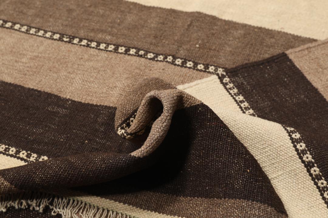 Handgeweven Kilim-tapijt uit het Midden-Oosten met een gestreept patroon in beige en bruine tinten.