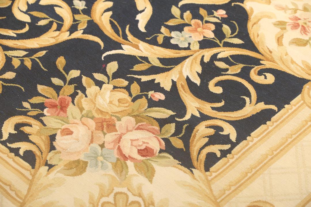 Een handgeweven Chinees tapijt met bloemmotieven op een donkerblauwe achtergrond