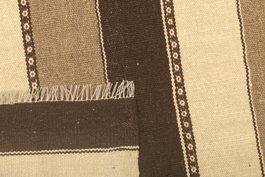 Et håndvævet mellemostligt kelimtæppe med vandrette brune og beige striber.