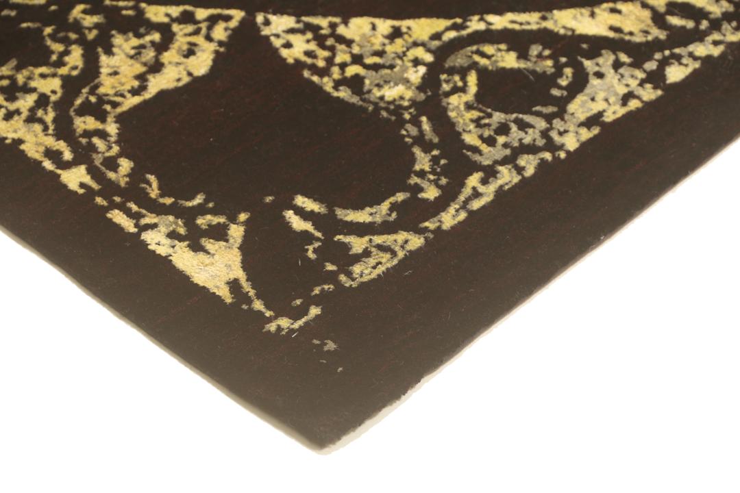 Un tapis moderne noué à la main originaire d'Inde avec un grand motif circulaire doré et noir.