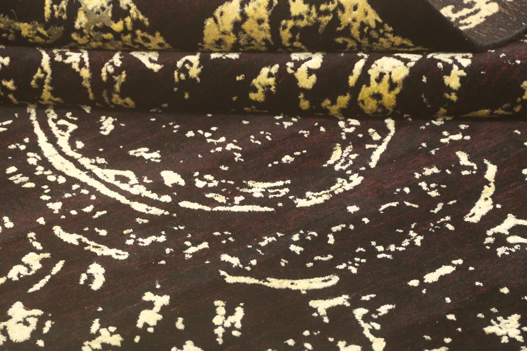 Un tapis moderne noué à la main originaire d'Inde avec un grand motif circulaire doré et noir.