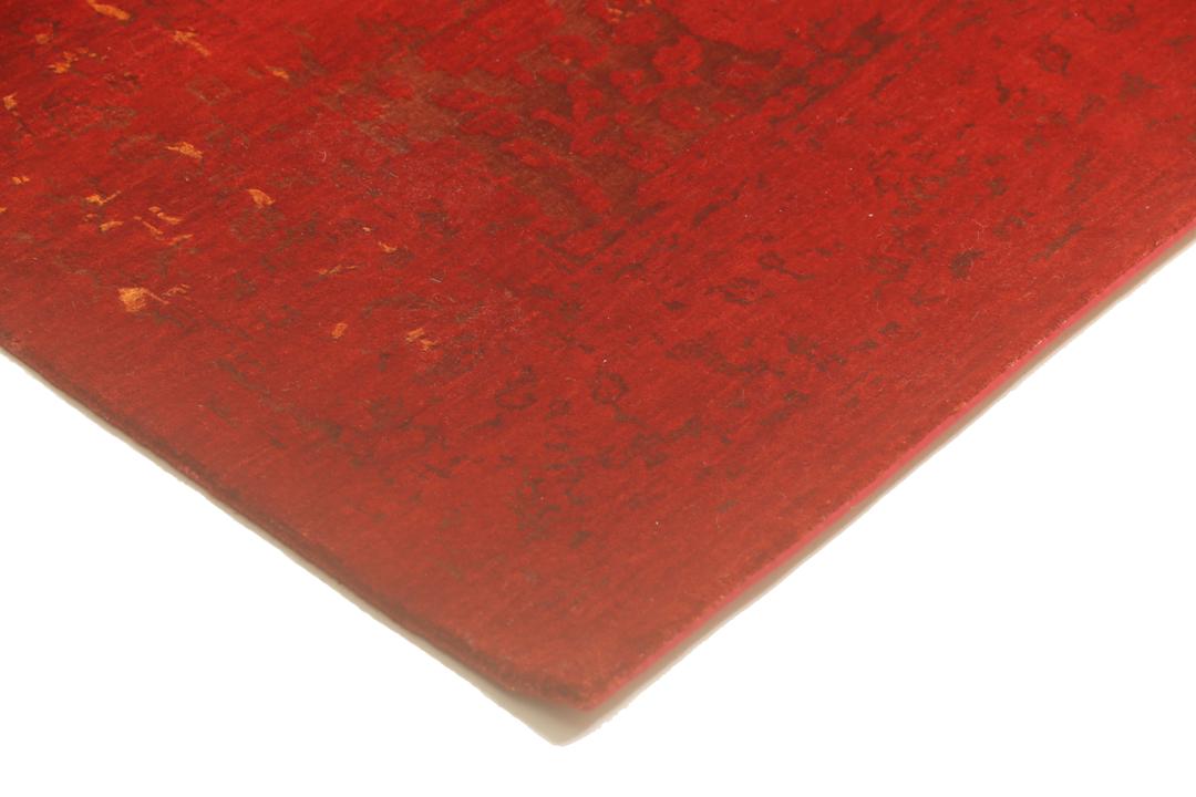 Een groot, rechthoekig handgeknoopt vloerkleed uit India met een levendig rood veld en organische gouden details.