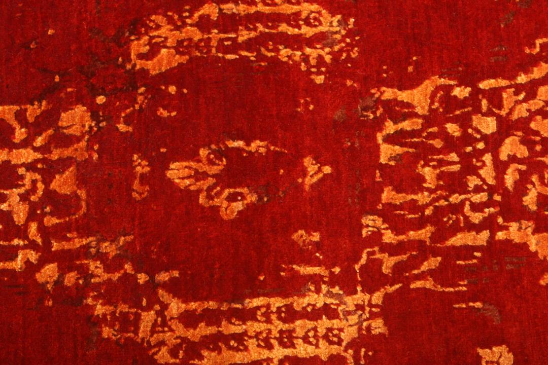 Een groot, rechthoekig handgeknoopt vloerkleed uit India met een levendig rood veld en organische gouden details.