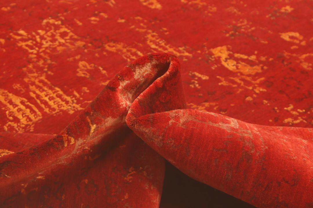Een groot, rechthoekig handgeknoopt vloerkleed uit India met een levendig rood veld en organische gouden details.