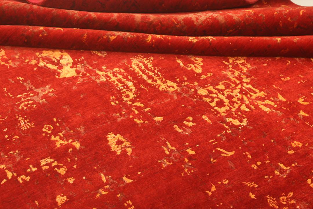 Een groot, rechthoekig handgeknoopt vloerkleed uit India met een levendig rood veld en organische gouden details.