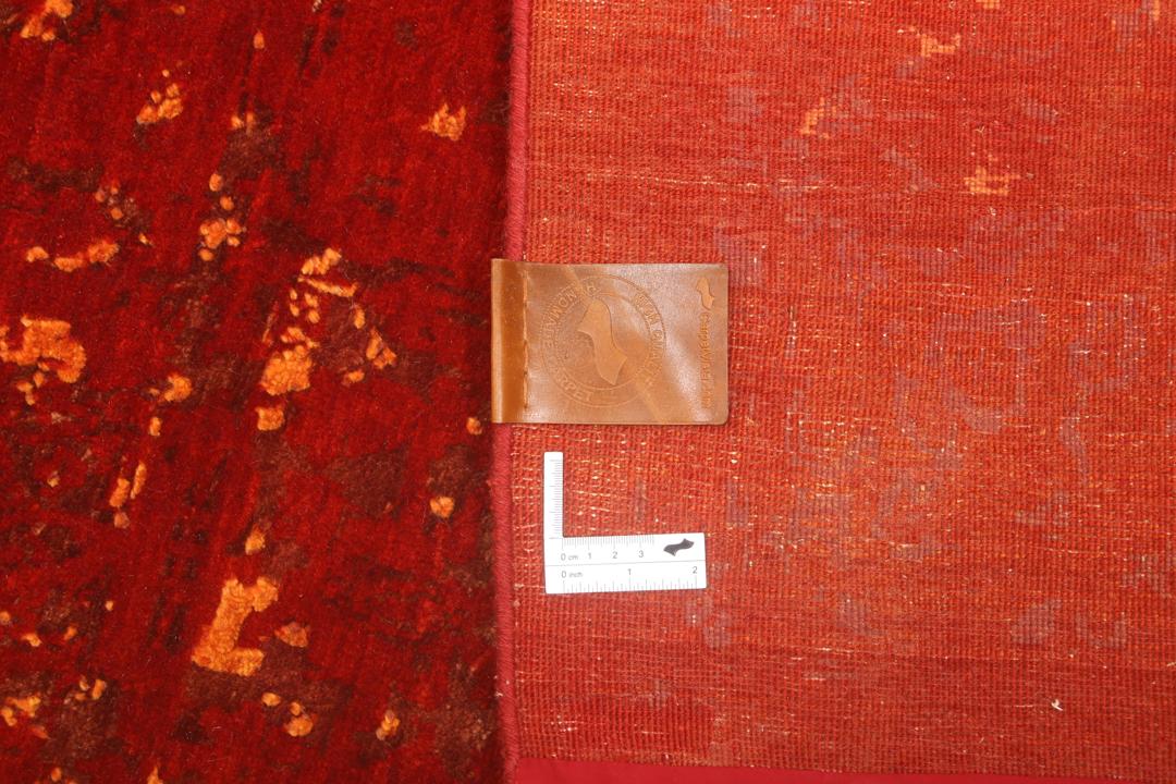 Een groot, rechthoekig handgeknoopt vloerkleed uit India met een levendig rood veld en organische gouden details.