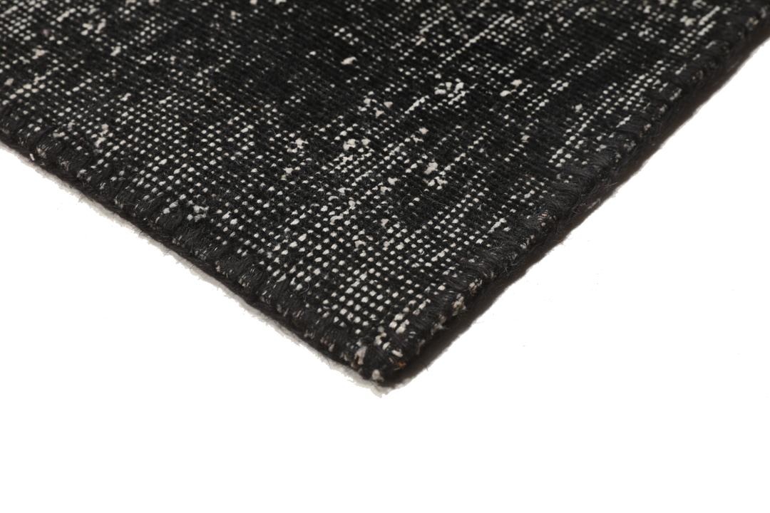 Een rechthoekig patchwork tapijt uit Turkije met een zwart-grijs ontwerp.