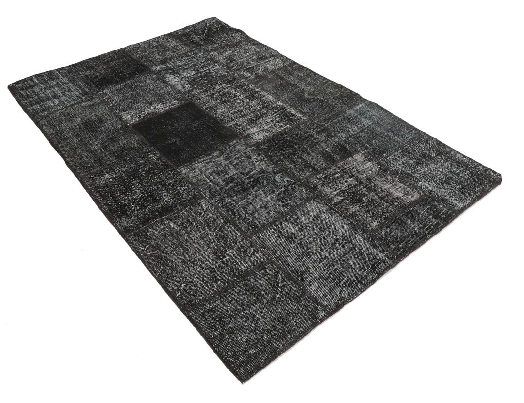 Een uniek handgemaakt patchwork tapijt uit Turkije in tinten zwart en antraciet.