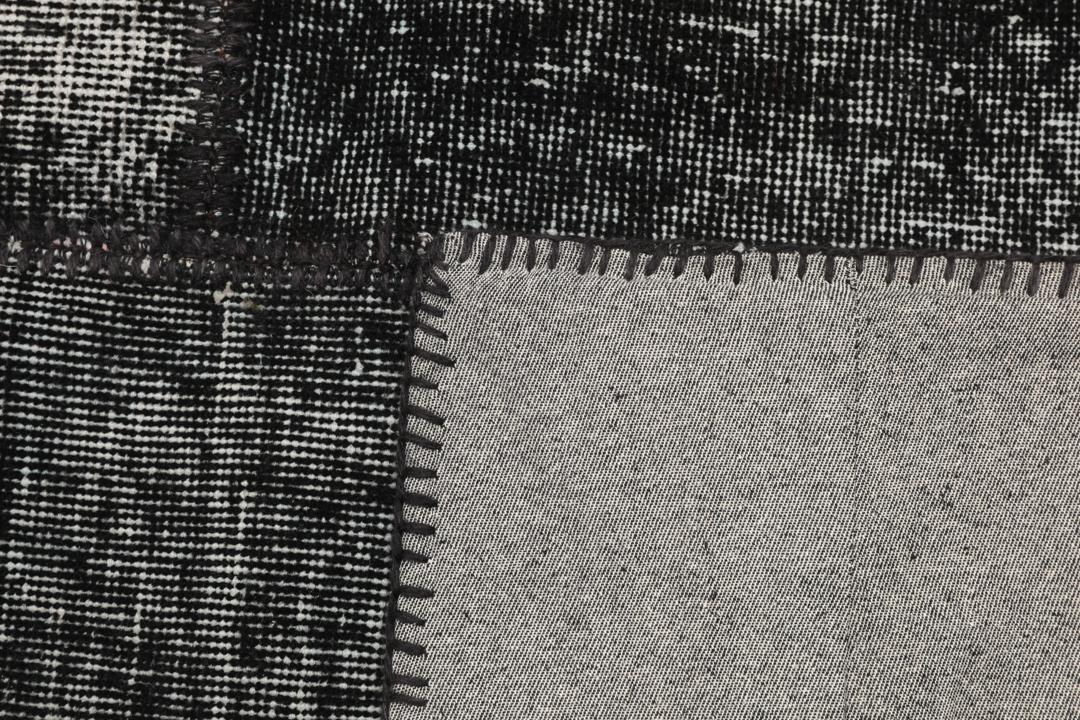 Een uniek handgemaakt patchwork tapijt uit Turkije in tinten zwart en antraciet.