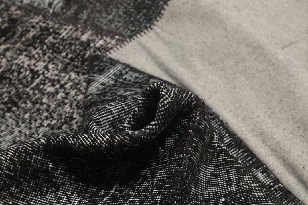 Een uniek handgemaakt patchwork tapijt uit Turkije in tinten zwart en antraciet.