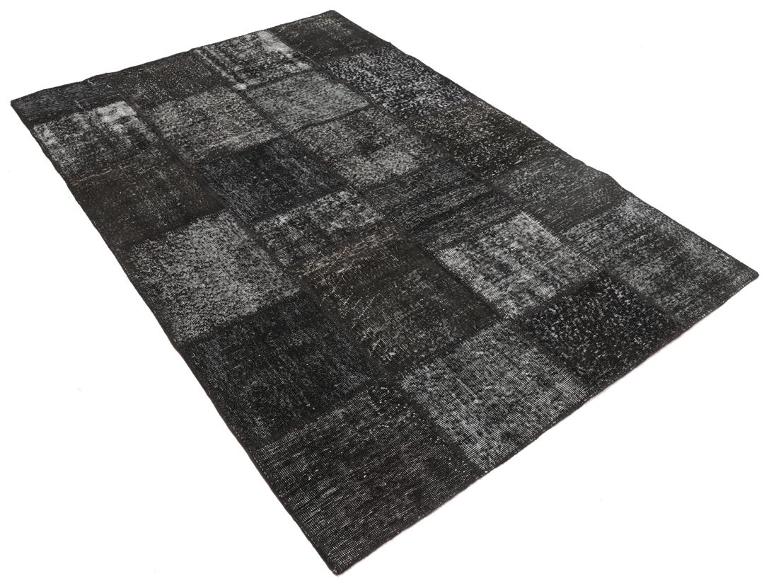 Een uniek, handgeknoopt zwart patchwork tapijt van Turkse oorsprong.