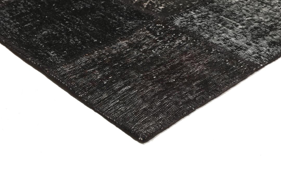 Een uniek, handgeknoopt zwart patchwork tapijt van Turkse oorsprong.