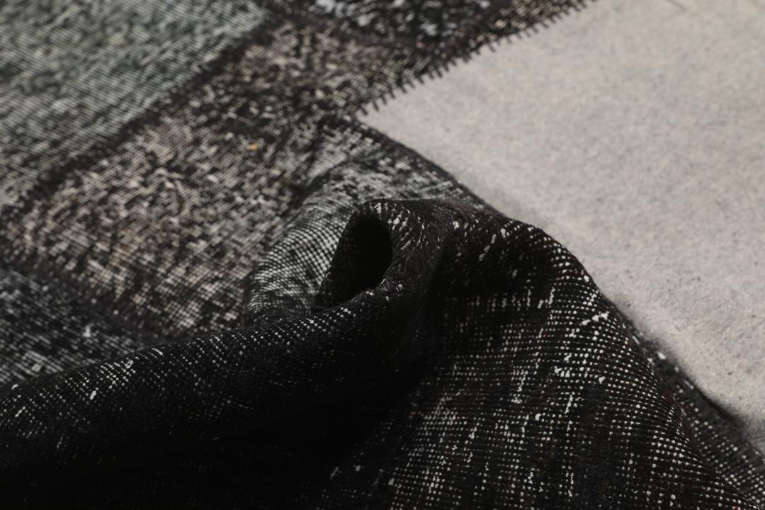 Een uniek, handgeknoopt zwart patchwork tapijt van Turkse oorsprong.