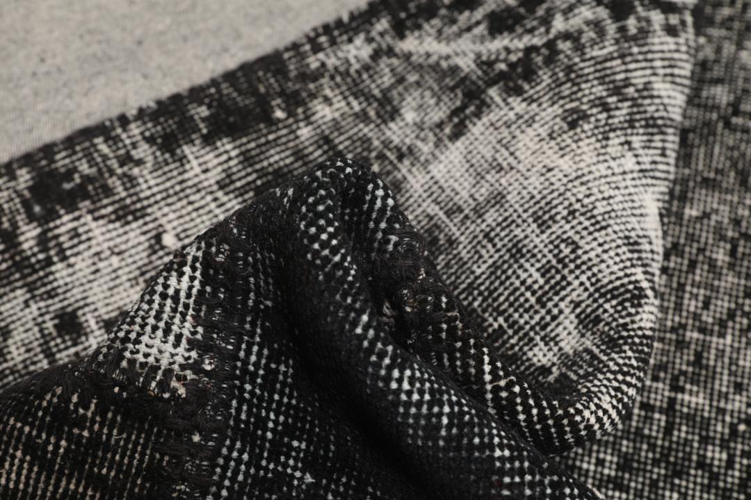 Een zwart patchwork tapijt met verschillende textuurpatronen uit Turkije