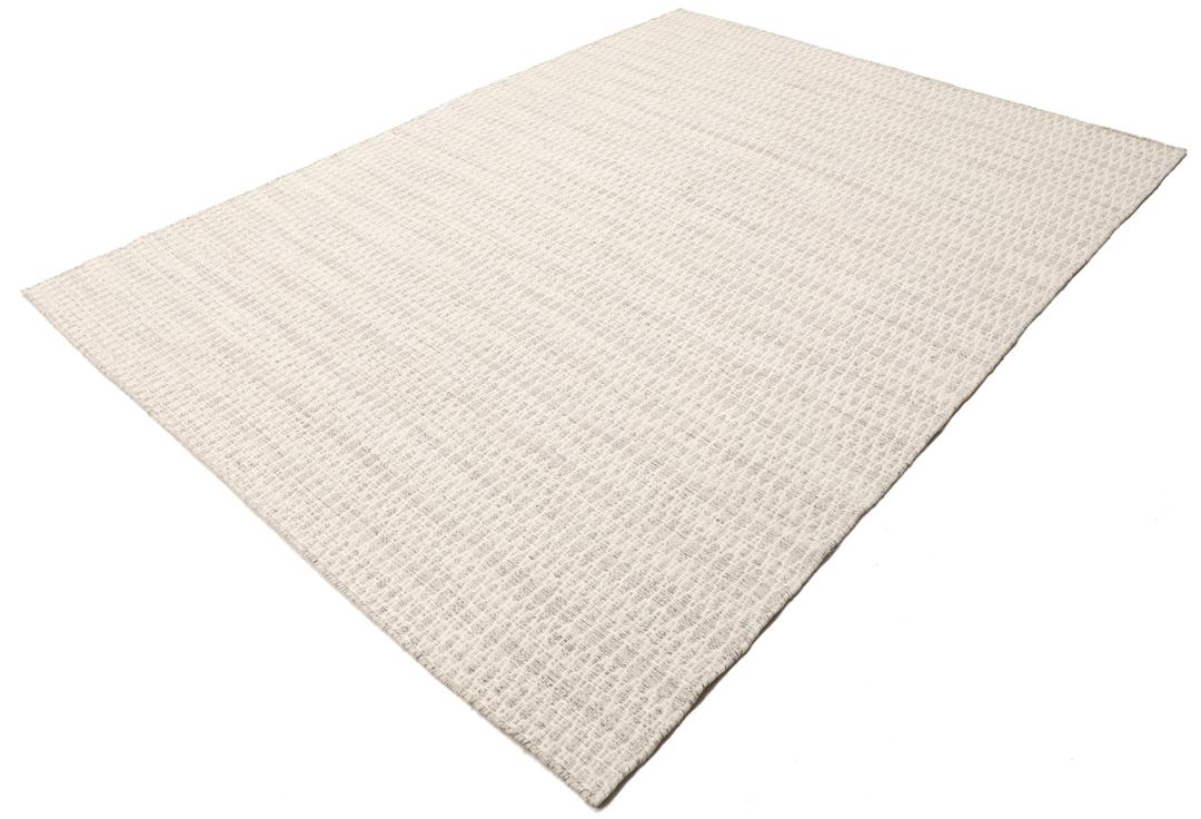 Beige tæppe med et struktureret vævet mønster