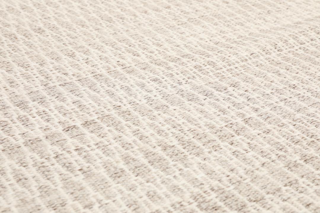 Beige tæppe med et struktureret vævet mønster