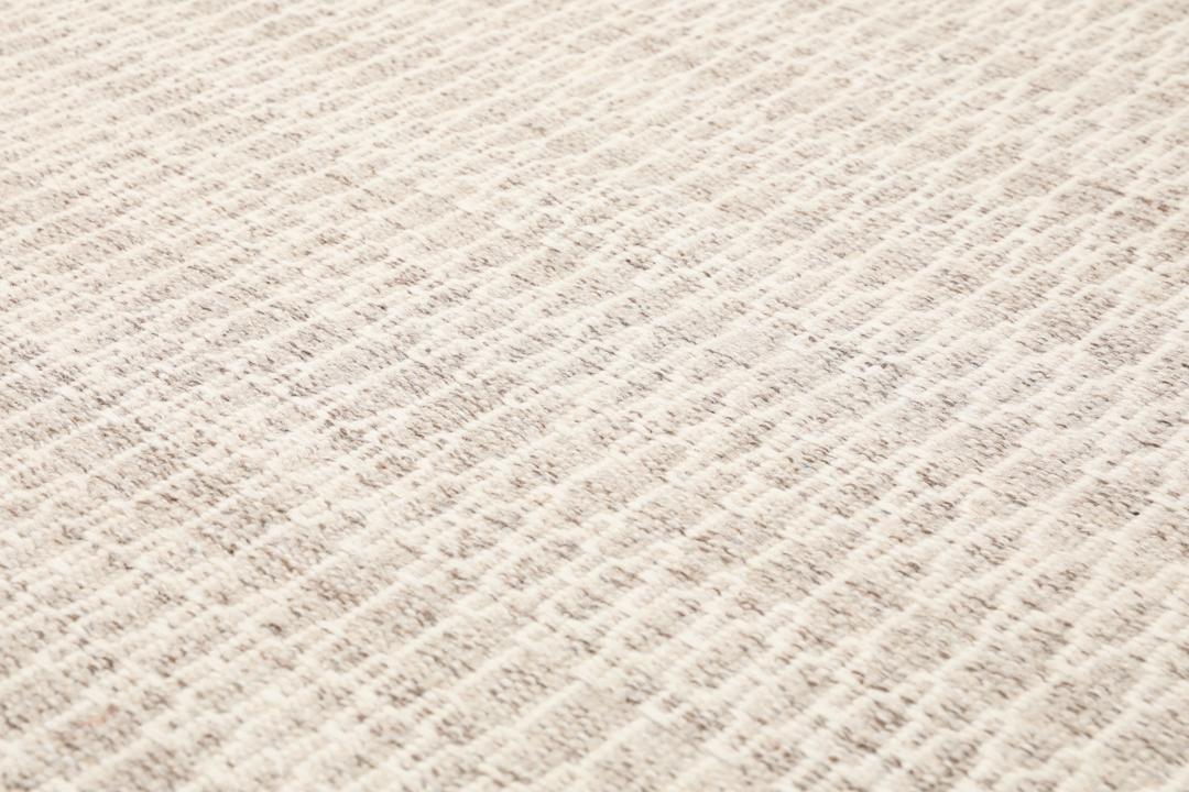 Beige tæppe med et struktureret vævet mønster