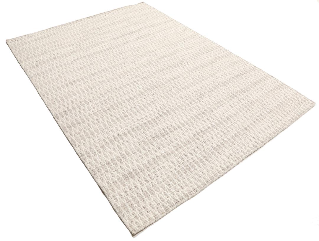 Beige tæppe med et struktureret vævet mønster