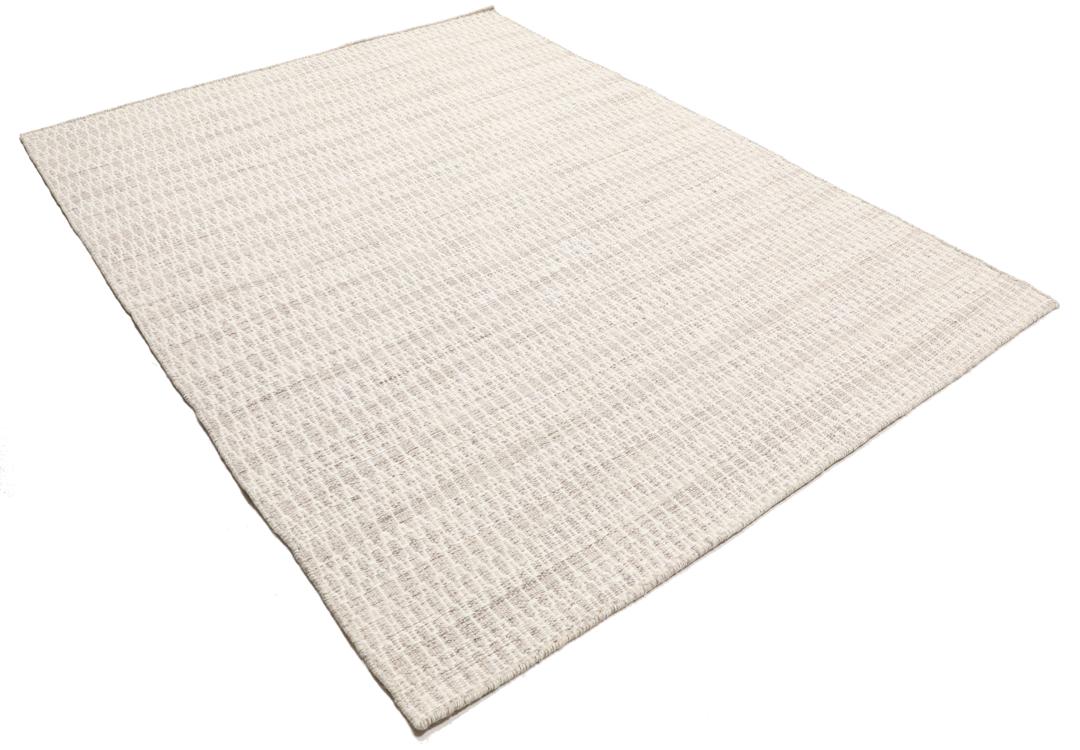 Beige tæppe med et struktureret vævet mønster