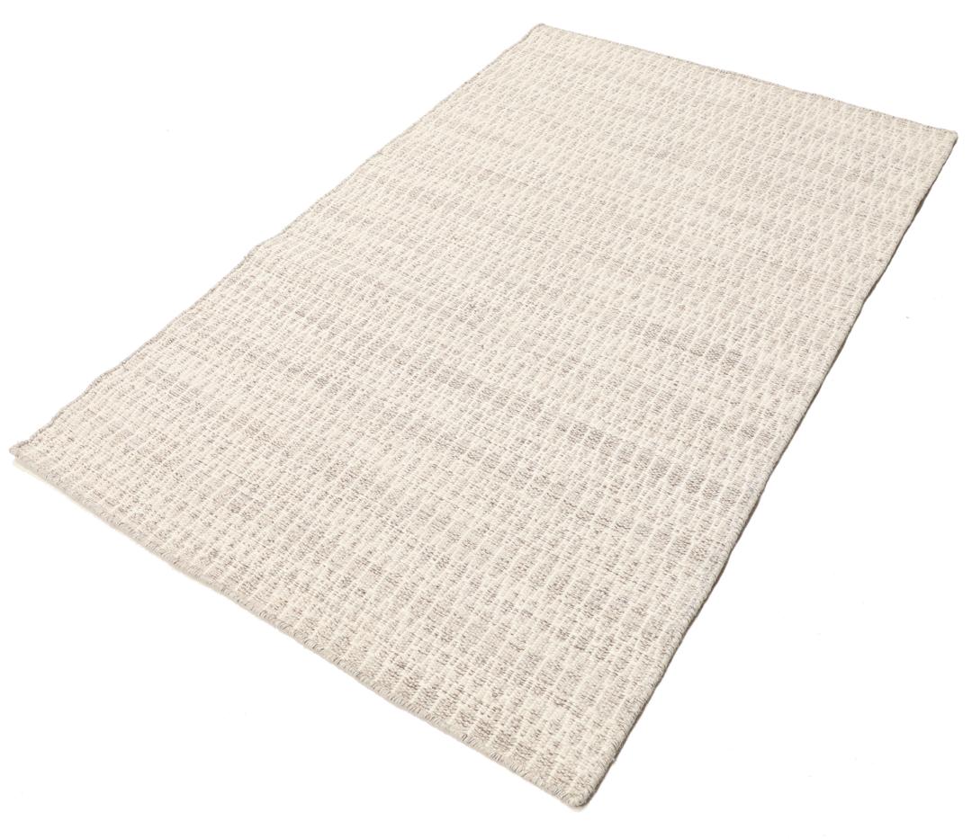 Beige tæppe med et struktureret vævet mønster