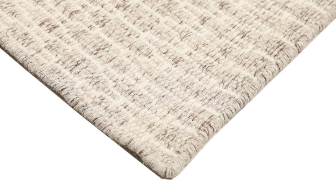 Beige tæppe med et struktureret vævet mønster